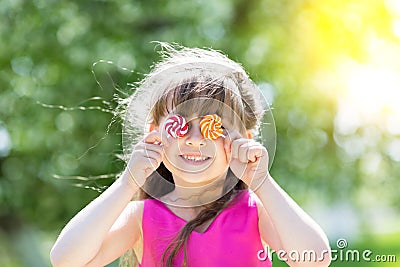 The little girl closed her eyes with sugar candies. Stock Photo