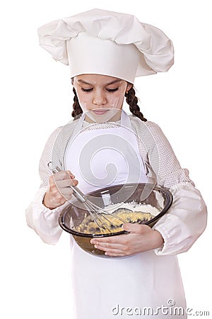 Little girl cook whips whisk eggs in a large plate Stock Photo