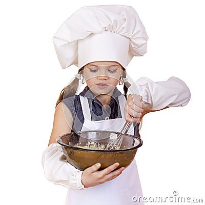 Little girl cook whips whisk eggs in a large plate Stock Photo