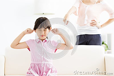 Little girl covering her ears while her mother angry Stock Photo