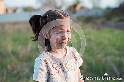 The little girl cries heavily outdoors. Children offense Stock Photo