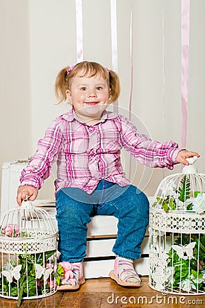 Little girl in a with decorative birdcages Stock Photo