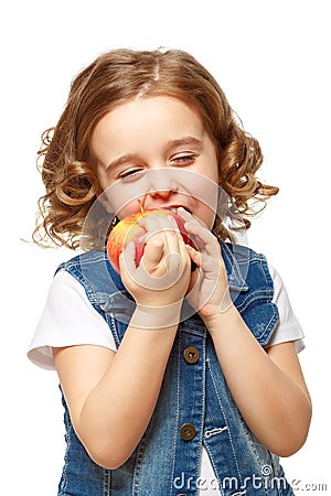Little girl in a denim jacket holding a red apple. Stock Photo