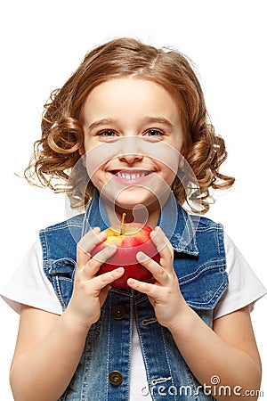 Little girl in a denim jacket holding a red apple. Stock Photo