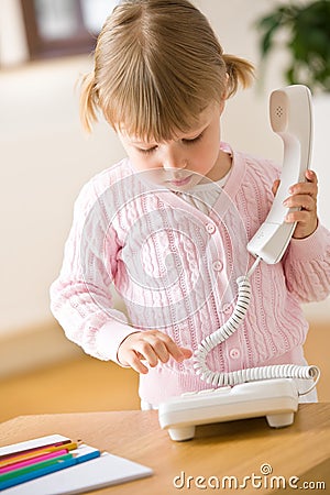 Little girl dial number on phone in lounge Stock Photo