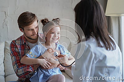 Little girl at the doctor for a checkup. Doctor woman auscultate the heartbeat of the child. Stock Photo