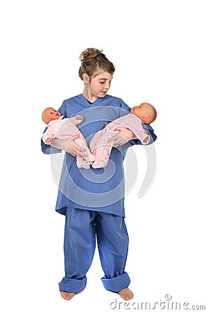 Little girl doctor holding twin baby dolls Stock Photo