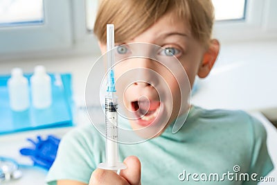 Little girl in doctor`s office is afraid of syringe with vaccine. Vaccination for covid-19 coronavirus,flu,dangerous infectious Stock Photo