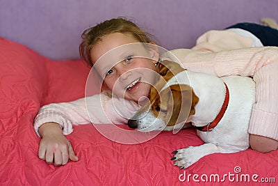 Little girl with dog at home in playroom. Stock Photo