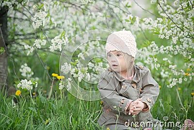 Little girl with Down syndrome in the mouth pulls dandelions Stock Photo