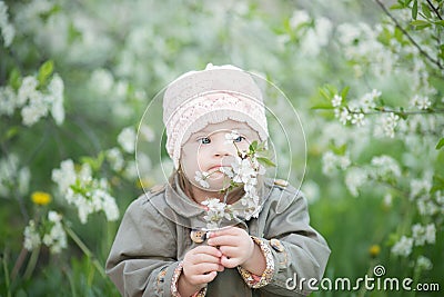 Little girl with Down syndrome smelling flowers Stock Photo