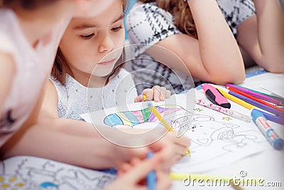 Little girl draws sitting at table in room Stock Photo