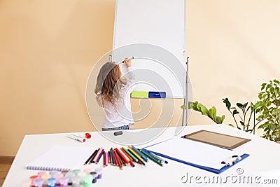 Little girl draws on the white board Stock Photo