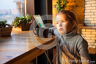 Little girl dreaming with a cup of tea Stock Photo