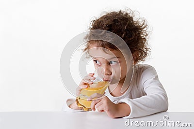 Little girl drinking orange juice Stock Photo