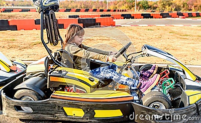 Little girl is driving Go- Kart car in a playground racing track Stock Photo