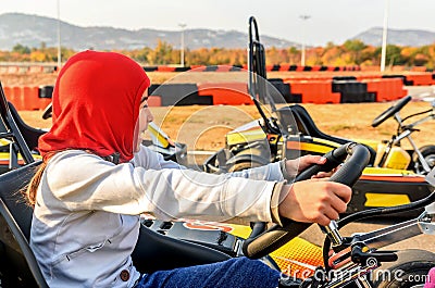 Little girl is driving Go- Kart car in a playground racing track Stock Photo
