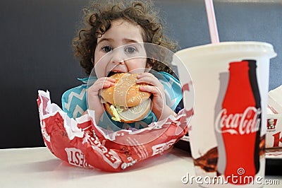 Little girl eating fast food Editorial Stock Photo