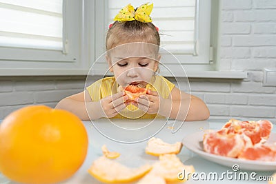 Little girl eating grapefruit Stock Photo