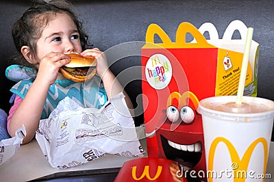 Little girl eats fast food Editorial Stock Photo