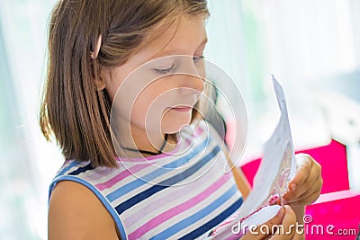 Little girl embroider a cross-stitch drawing Stock Photo