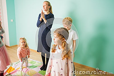 Little girl enjoying game with friends and teacher in kindergarden. Happy and healthy childhood. Stock Photo