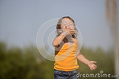 Little girl enjoying the light summer rain. Stock Photo