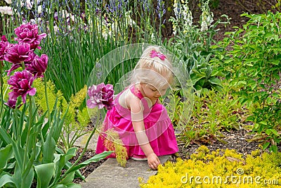 Little girl exploring a sensory garden in Spring Stock Photo