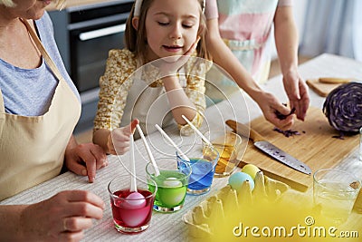 Little girl with family preparation natural dyes for coloring eggs Stock Photo