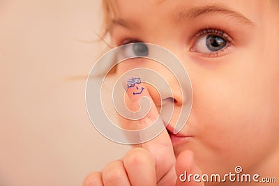 Little girl and finger with painted face Stock Photo