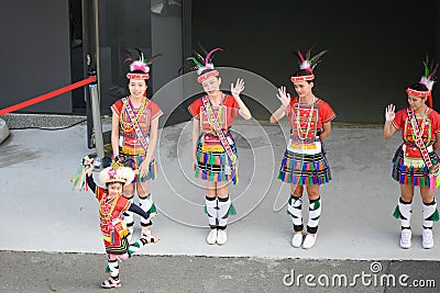 Cute little Taiwanese girl in garb with dancing group of Amis Tribe from Hualien with headdress and skirt, Kaohsiung, Taiwan Editorial Stock Photo