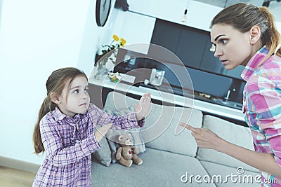 The little girl is frightened and protected from babysitting. She curses the girl and threatens her with a finger. Stock Photo