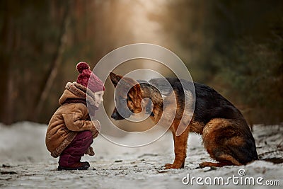 Little girl with German shepherd 6-th months puppy at early spring Stock Photo