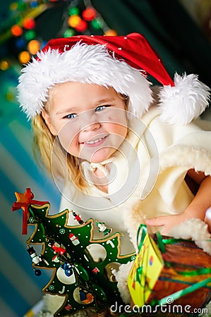 Little girl with gift and Christmas tree Stock Photo