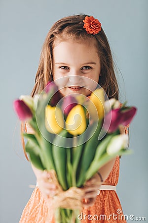 Little girl giving colorful flowers, smiling sincerely Stock Photo