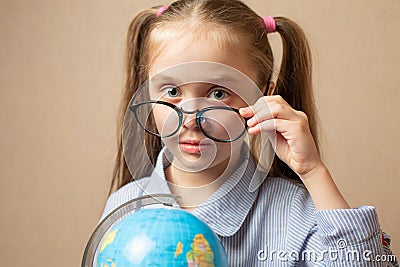 Little girl in glasses holding globe Stock Photo