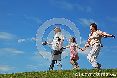 Little girl and grandparents running on hill Stock Photo