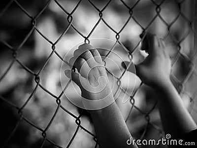 Little girl hand holding on chain link fence for freedom, Human Stock Photo