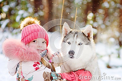Little girl and hasky dog together in winter park Stock Photo
