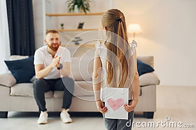 Little girl have gift for man. Father with his little daughter is at home together Stock Photo