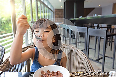 Little girl having breakfast on table Stock Photo