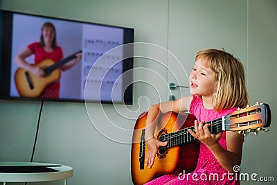 Little girl having guitar lesson online at home Stock Photo