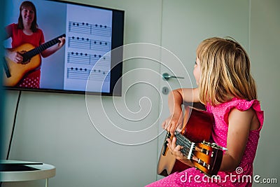 Little girl having guitar lesson online at home Stock Photo