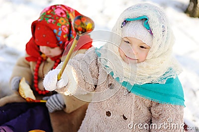 Little girl in a headscarf in the Russian style, with a wooden s Stock Photo