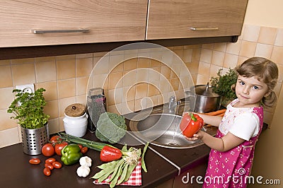 Little girl helping in kitchen Stock Photo