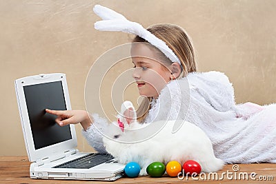 Little girl with her bunny using computer together Stock Photo