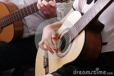 little girl and her father are playing guitar. Learning to play the guitar. Music education and extra-curricular lessons Stock Photo