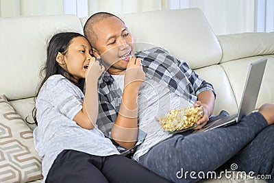 Child and father watching a movie on a laptop Stock Photo