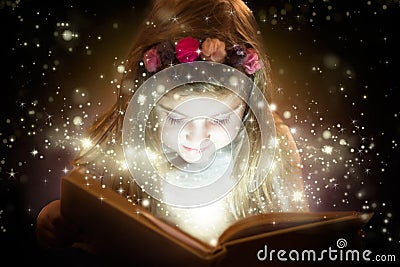 Beautiful little girl reading her magic book Stock Photo