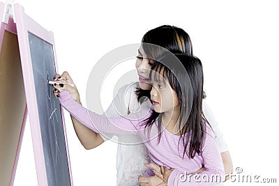 Little girl with her mother drawing with chalk Stock Photo